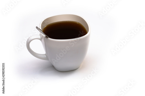 White cup of coffee with a spoon on an isolated background. Black cappuccino drink in a bowl