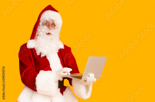 Astonished Santa Claus chatting with children through the Internet
