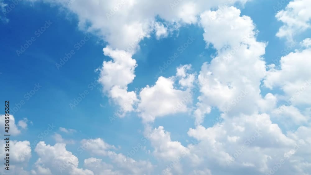 White puffy clouds and blue sky time-lapse with long second duration for background and graphics in daylight.