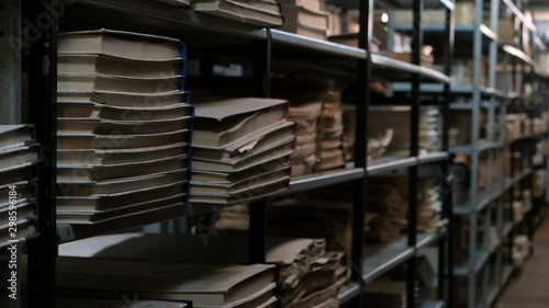 Bookshelves in an old library or archive room. Old room with books and documents with a basement light. Footage for the concept of training and historical news.