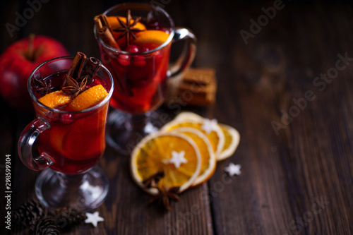 Mulled wine with aromatic spices and fruits on wooden rustic table, copy space. Traditional Christmas time hot drink
