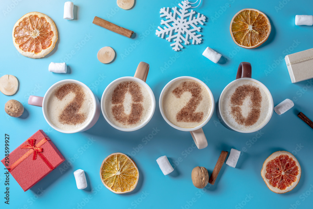 Card with numbers 2020 for New year and Christmas. Cup of coffee with figures on blue background. Top view. Flat lay Card with numbers 2020 for New year and Christmas. Cup of coffee with figures on blue background. Top view. Flat lay