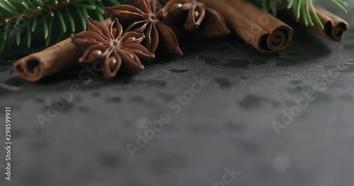 Tilt shot of spruce twig with cinnamon and anise on terrazzo countetop photo