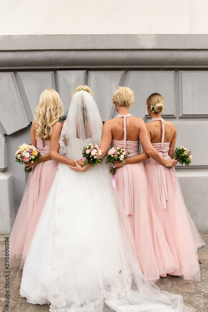 Bride and bridesmaids in pink dresses posing with bouquets at wedding day.  Happy marriage and wedding party concept Stock Photo | Adobe Stock
