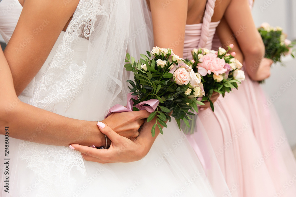 Bride and bridesmaids in pink dresses posing with bouquets at wedding day. Happy marriage and wedding party concept Bride and bridesmaids in pink dresses posing with bouquets at wedding day. Happy marriage and wedding party concept
