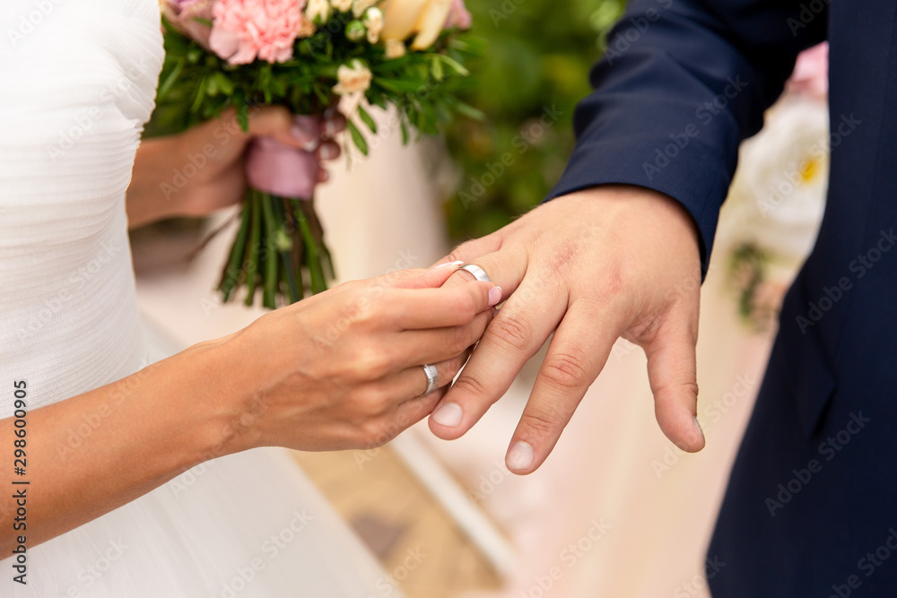 Wedding, marriage concept. Bride puts wedding ring on groom’s finger on wedding day Wedding, marriage concept. Bride puts wedding ring on groom’s finger on wedding day