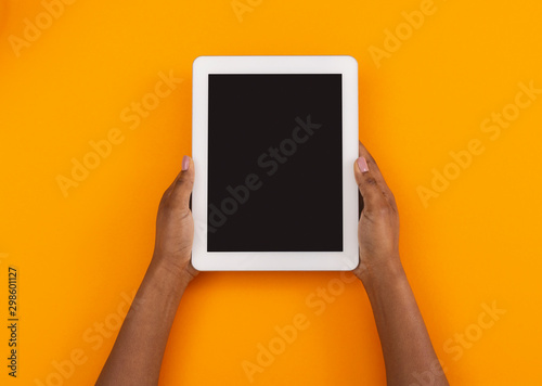 Modern digital tablet with black screen in black woman's hands