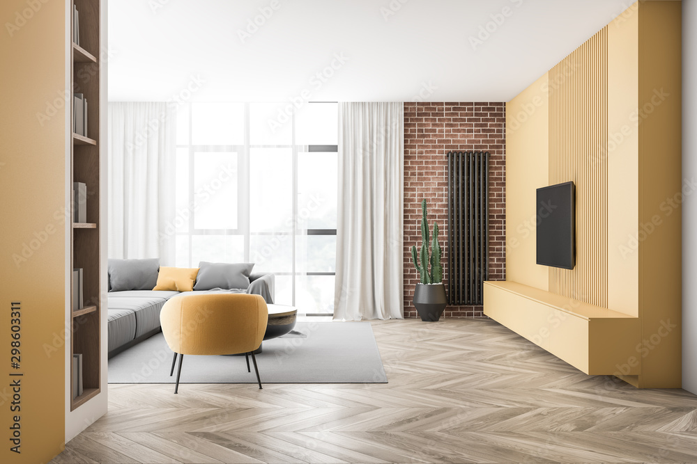 Fototapeta premium Brick and yellow living room with sofa and TV