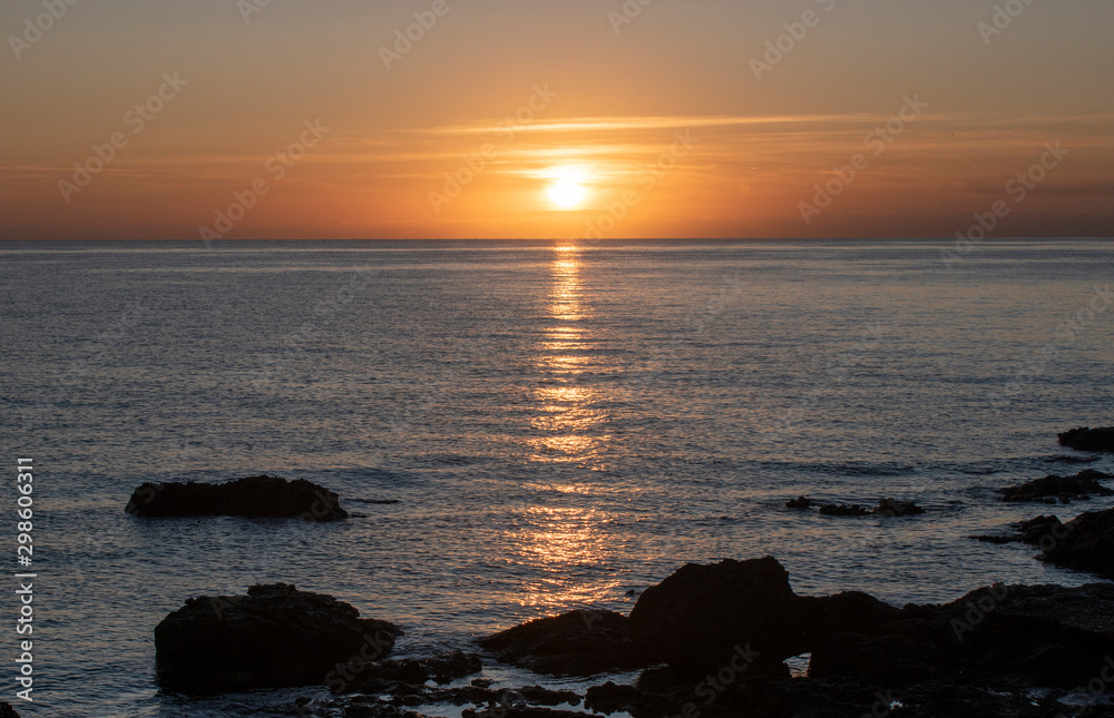 Cala Bona Majorca a beautiful sunrise over the Mediterranean with the sun rays reflecting off the sea. 