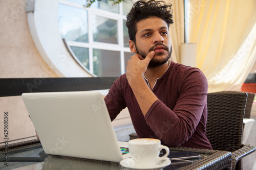 Portrait of young, hopeful Asian man in work. Young businesssman is working in a cafeteria. Business From coffee shop. photo