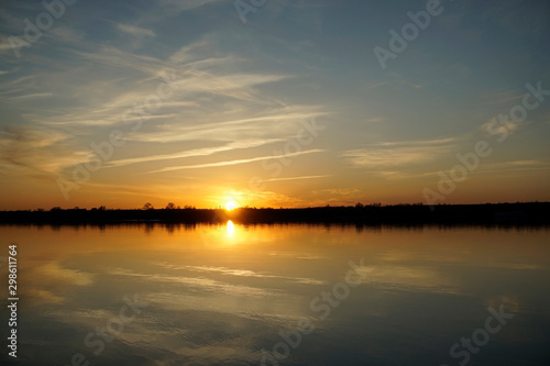 Fototapeta Naklejka Na Ścianę i Meble -  Riverbank in the evening sun. Blue sky