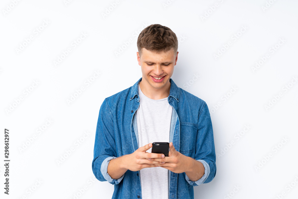 Young handsome man over isolated white background sending a message or email with the mobile
