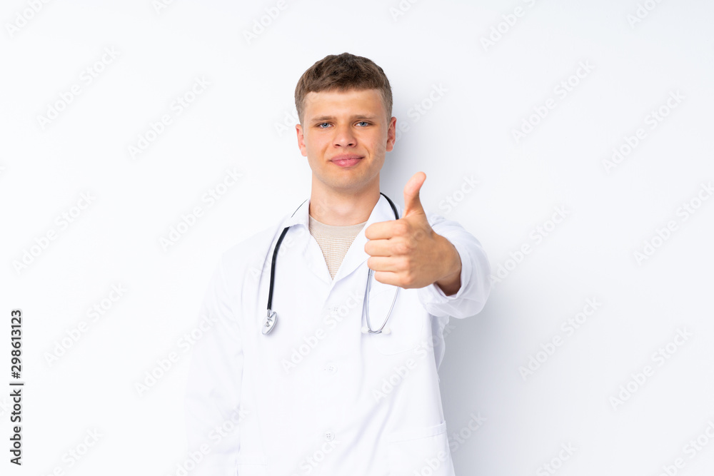 Young handsome man over isolated white background with doctor gown and with thumb up Young handsome man over isolated white background with doctor gown and with thumb up