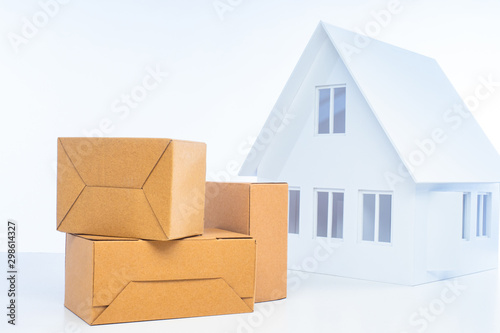 Concept - Warehouse rental. Boxes at home. Parcels near the house. The concept is unloading things. Delivery to the door. Corton boxes next to the cottage. Cargo delivery. Warehousing services.