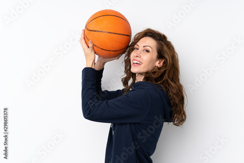 Young pretty woman over isolated background with ball of basketball © luismolinero