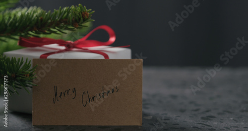 merry christmas paper card next to gift box