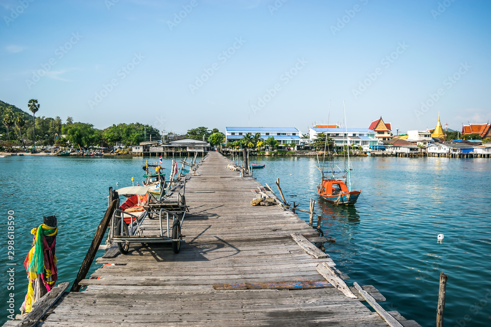 The old wooden jetty with rope and fishing boats at The old wooden jetty at Sattahip, Chonburi province, Thailand