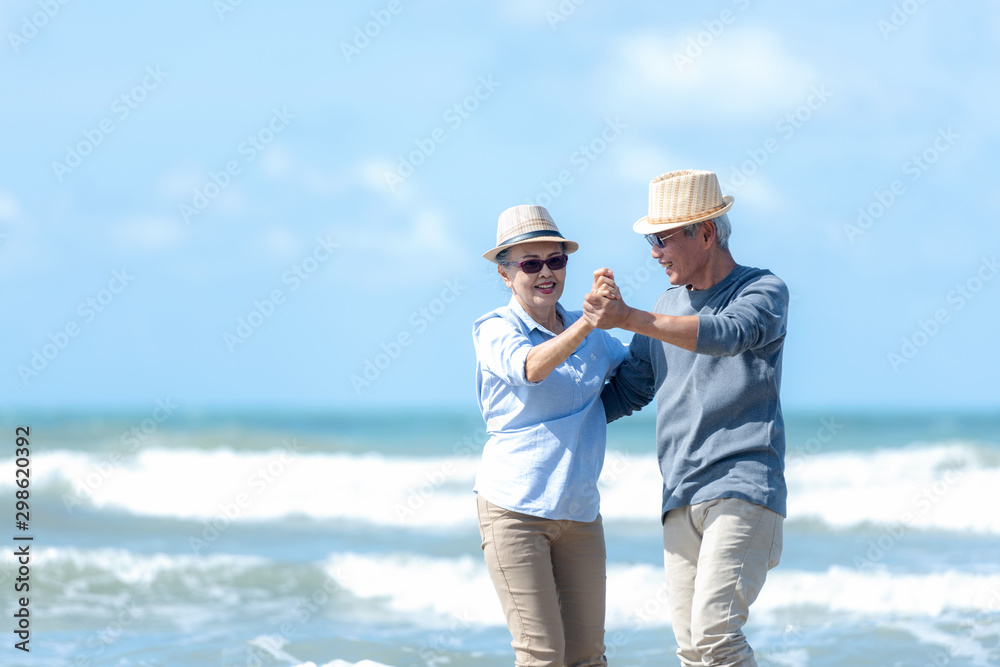 Asian Lifestyle senior couple dancing on the beach happy and relax time.  Tourism elderly family travel leisure and activity after retirement in vacations and summer..