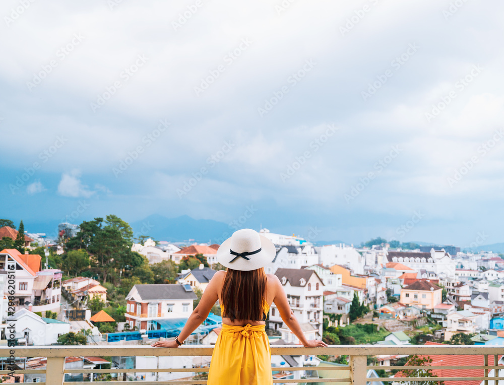young woman in hat on balcony  looking the city, travel concept background.