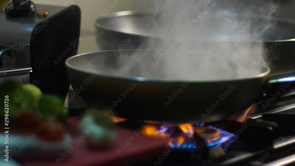 The chef preparing spaghetti in a frying pan on a gas stove in the kitchen. Slow-motion. Close up. The chef preparing spaghetti in a frying pan on a gas stove in the kitchen. Slow-motion. Close up.