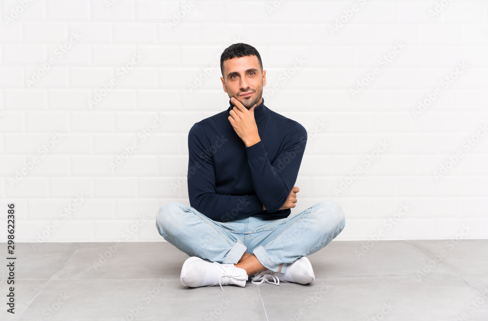 Young handsome man sitting on the floor laughing Young handsome man sitting on the floor laughing