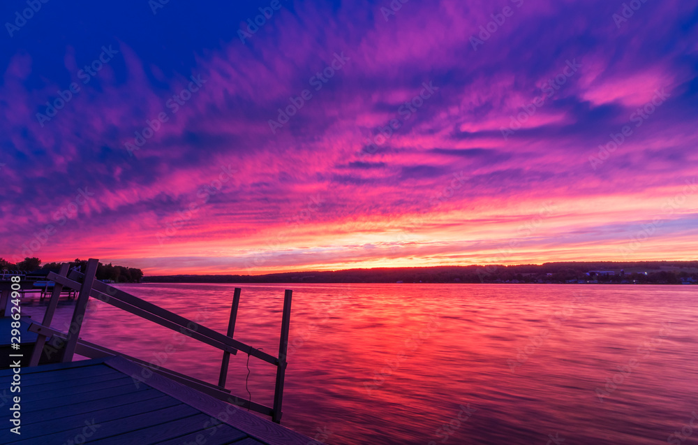 Vivid ultra violet sunset over calm water at Silver Lake, NY State