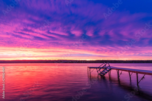 Vivid ultra violet sunset over calm water at Silver Lake, NY State © rabbitti