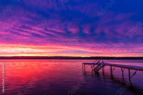 Vivid ultra violet sunset over calm water at Silver Lake, NY State
