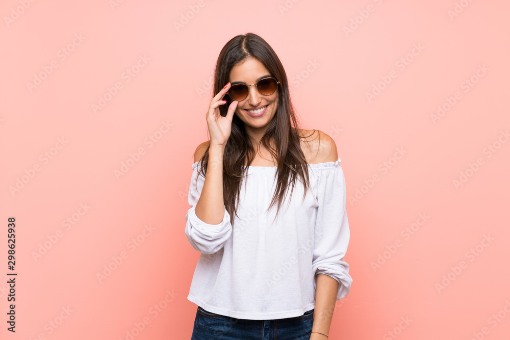 Young woman over isolated pink background with glasses and happy Young woman over isolated pink background with glasses and happy