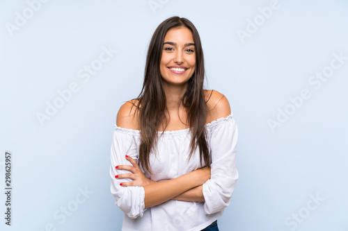 Young woman over isolated blue background laughing photo