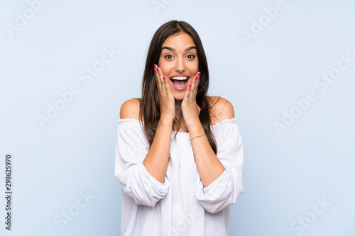 Young woman over isolated blue background with surprise facial expression photo