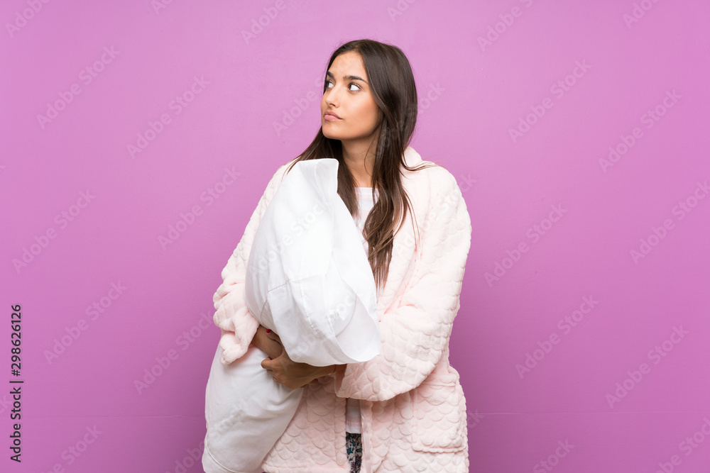 Young woman in pajamas and dressing gown over isolated purple background thinking an idea Young woman in pajamas and dressing gown over isolated purple background thinking an idea