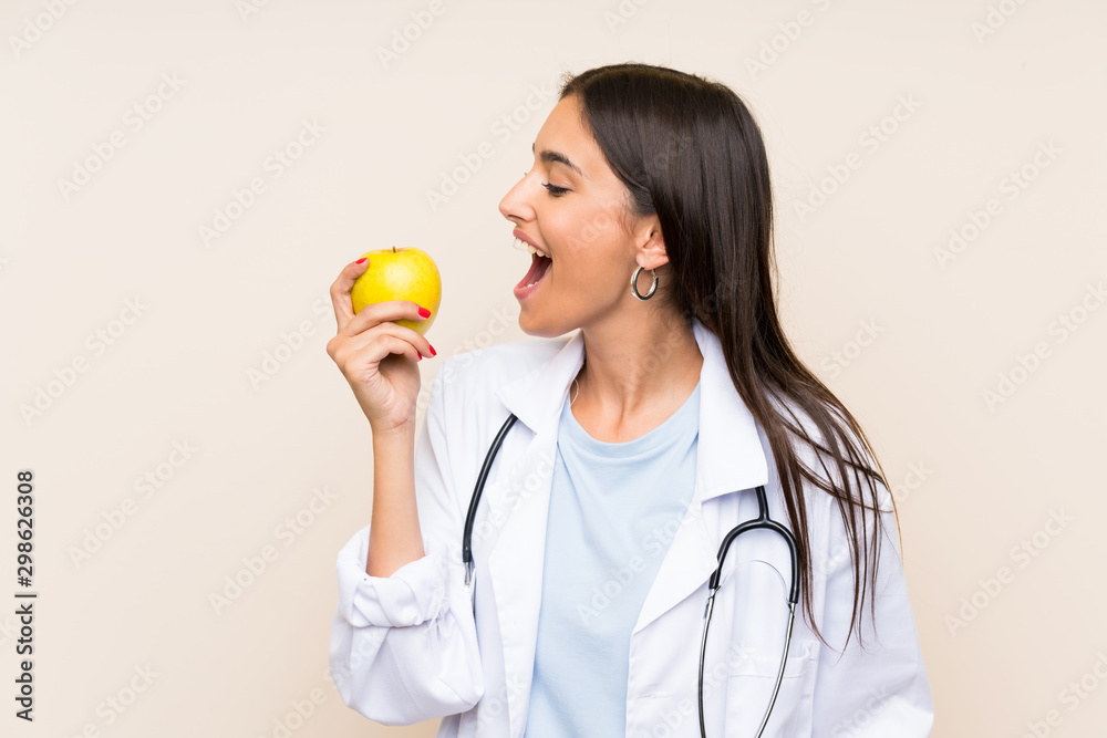 Young doctor woman over isolated background with an apple Young doctor woman over isolated background with an apple