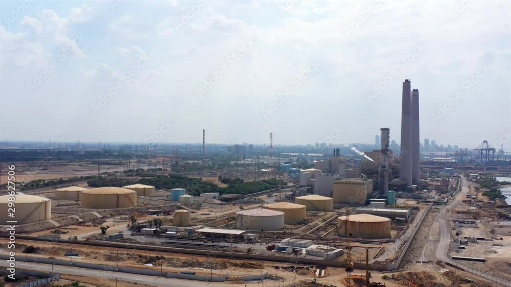 Drone view over Power Plant with Fuel Tanks and chimneys in the Middle east Drone view over Power Plant with Fuel Tanks and chimneys in the Middle east