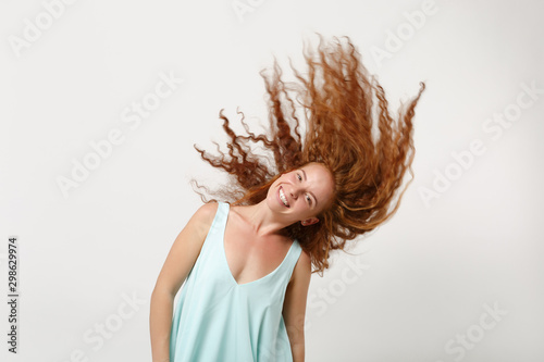 Young cheerful redhead woman girl in casual light clothes posing isolated on white background in studio. People lifestyle concept. Mock up copy space. Having fun, fooling around with flowing hair.