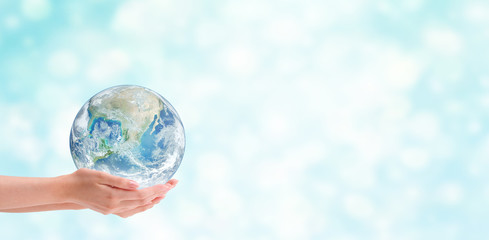 Ecology Concept : Hand holding blue planet earth globe with blurred bokeh background . (Elements of this image furnished by NASA.)