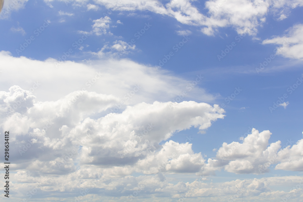 Fototapeta premium White cumulus clouds in blue sky at daytime. Natural background photo texture