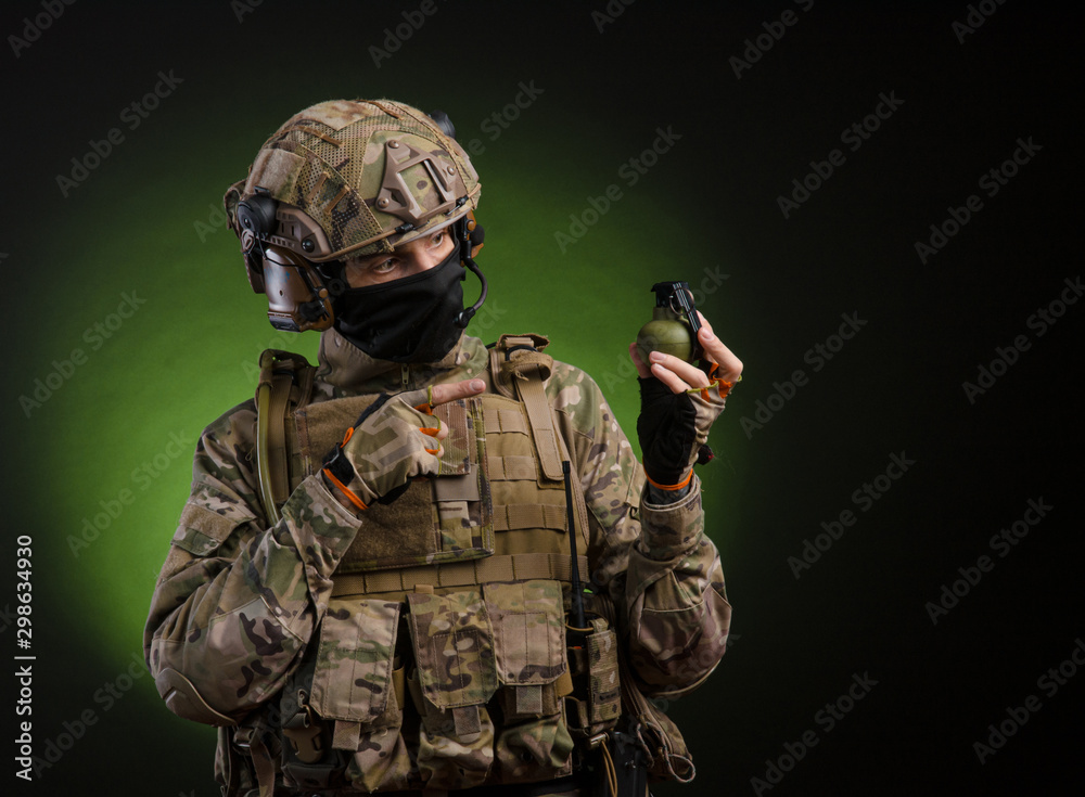 a male soldier in military clothes with a weapon on a dark background a male soldier in military clothes with a weapon on a dark background