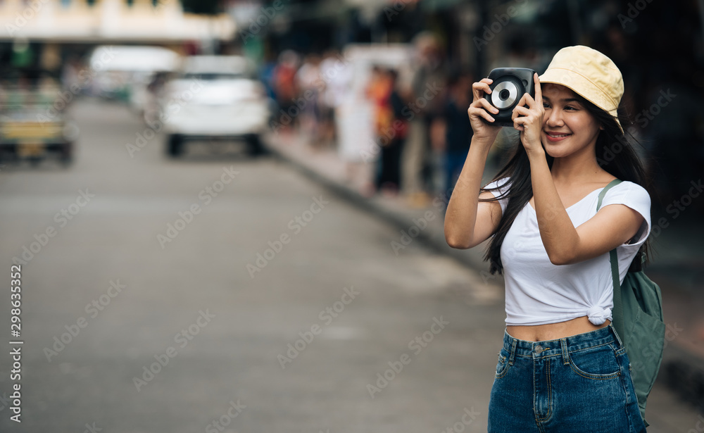 Traveller backpack woman with instant camera on the street, travel vacation in the city concept.