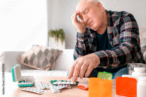 Elderly man with pills at home