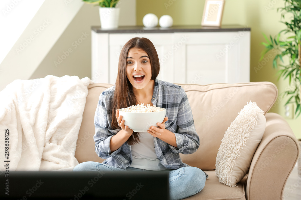 Emotional woman with popcorn watching movie at home Emotional woman with popcorn watching movie at home