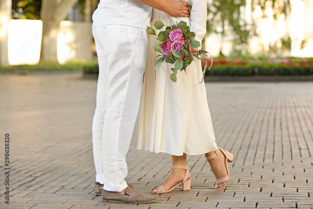 Happy young couple with bouquet of flowers on romantic date outdoors Happy young couple with bouquet of flowers on romantic date outdoors