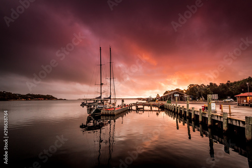 Obraz na płótnie Sailing boat with idyllic sunset in Strahan, Tasmania one of the most remote places in Australia at the end of the world with beautiful colors in the sky, starting point for a trip on the Gordon River w salonie