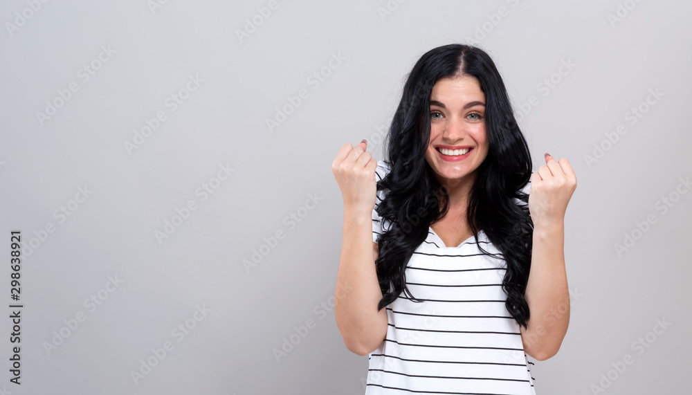 Successful young woman on a gray background