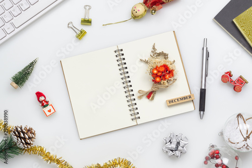 Top view of blank notebook on white  background with xmas decorations. Mockup Christmas background with notebook for wish list or to do list. Flat lay with copy space.