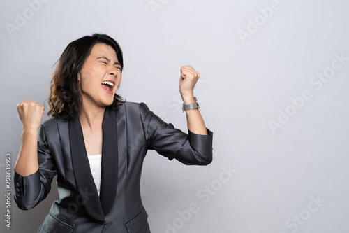 Happy woman make winning gesture isolated over white background