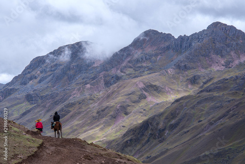 Horse driver and tourist are going to the Rainbow Mountains (Peru)