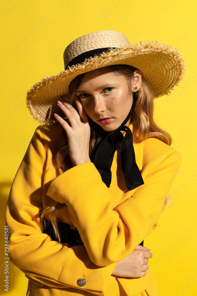Pretty blonde girl with freckles in yellow outfit and straw hat Pretty blonde girl with freckles in yellow outfit and straw hat