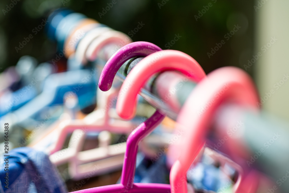 Colourful plastic clothes hang on stainless steel clothes rack, Close up shot, Selective focus, Light & Shadow, Laundry work concept