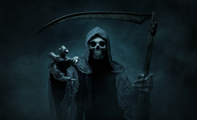 Grim reaper reaching towards the camera over dark, misty background with copy space